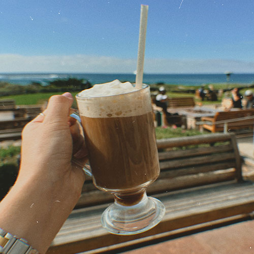 snapshot of irish coffee in front of the ocean